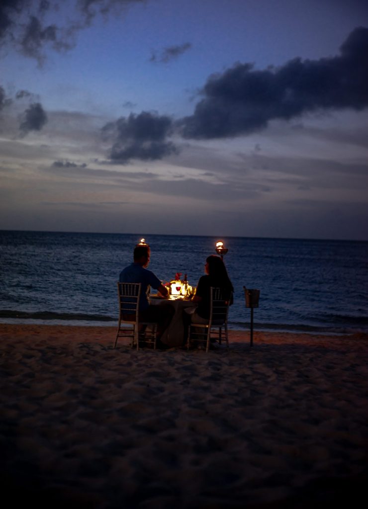couple sitting at seashore having dinner date