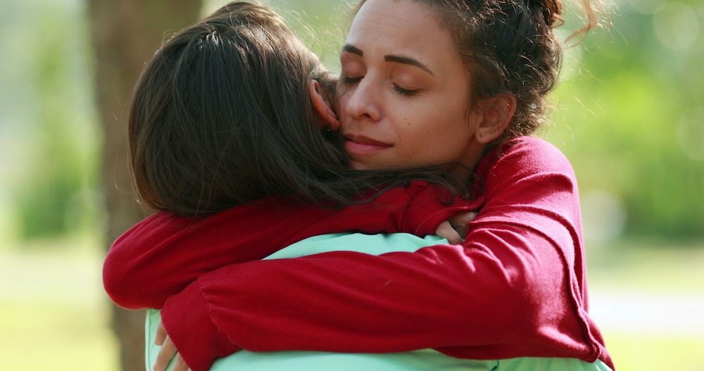 An empathic woman hugging her friend.