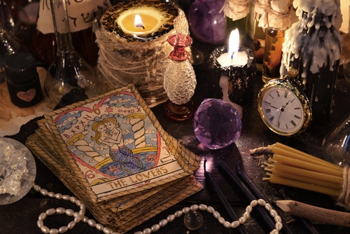 Close-up of tarot cards, candles, and crystals for a love reading.