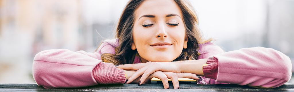 female smiling with eyes closed.