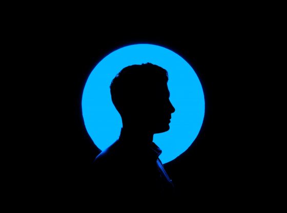 silhouette of man in front of blue light