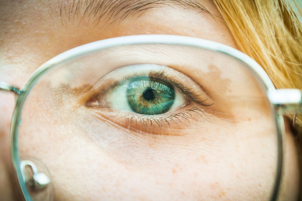 green eye behind glasses