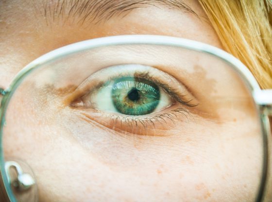 green eye behind glasses