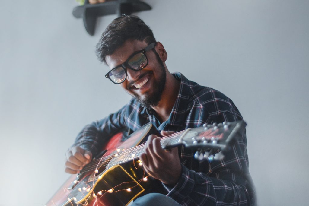 smiling man playing guitar