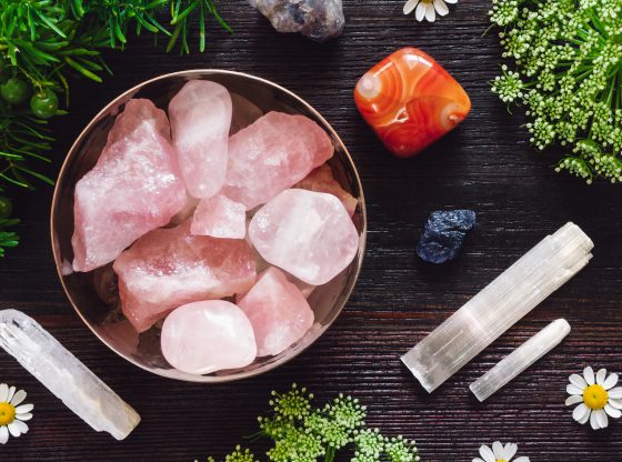 flatlay of rose quartz, crystals and flowers