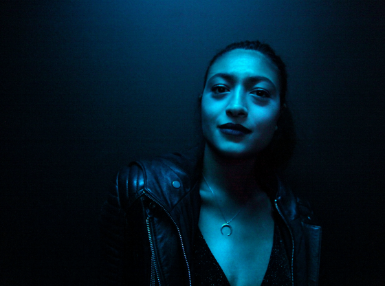 woman standing under turquoise light
