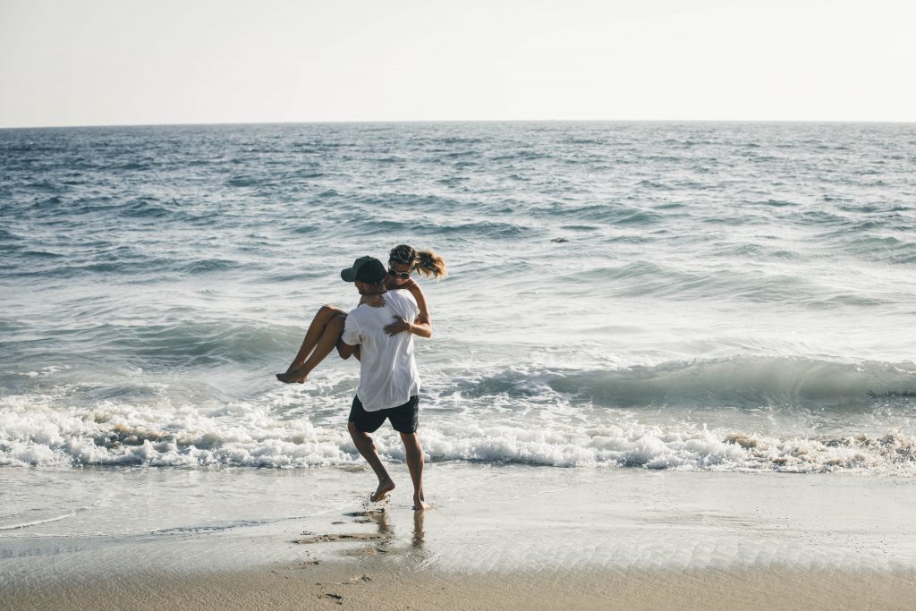 couple holding each other at the beach.
