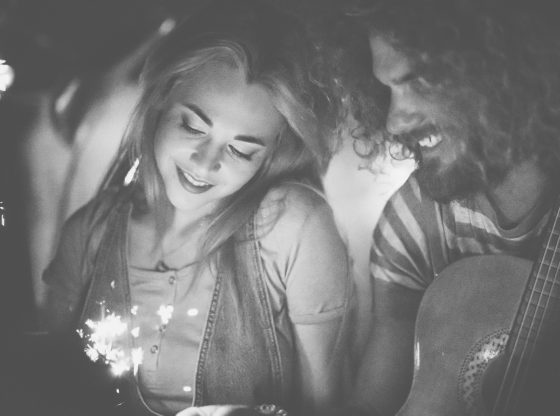 Young hipster couple on a date celebrating with sparklers