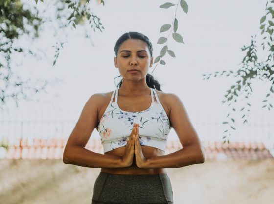 woman meditating with hands together