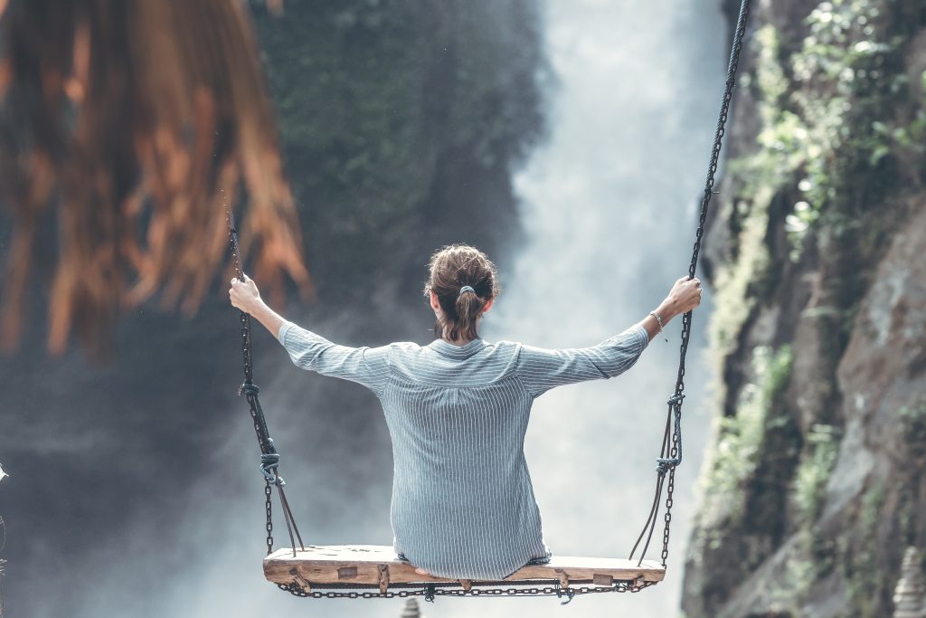 woman swinging near waterfall