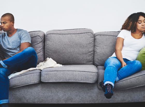 young couple sitting on opposite sides of the couch