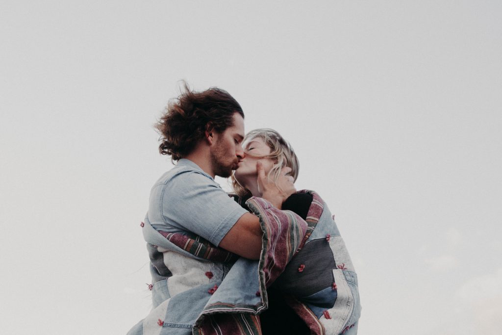 man kissing woman in the wind