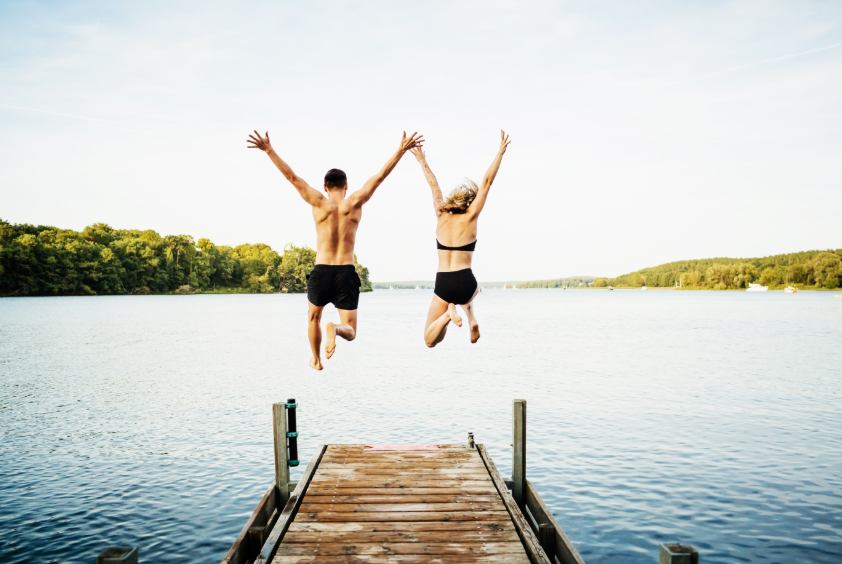 couple jumping into lake