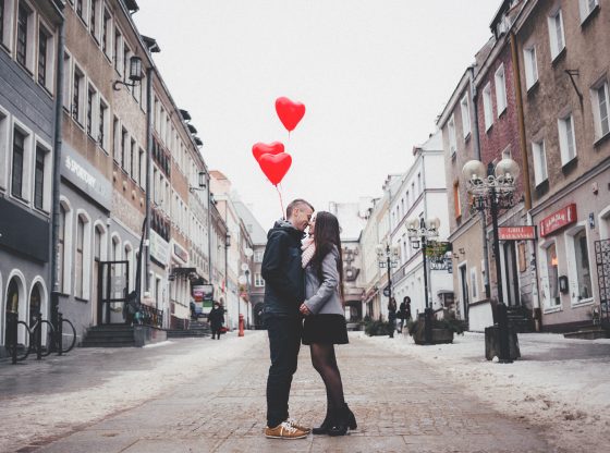 couple kissing with heart balloons