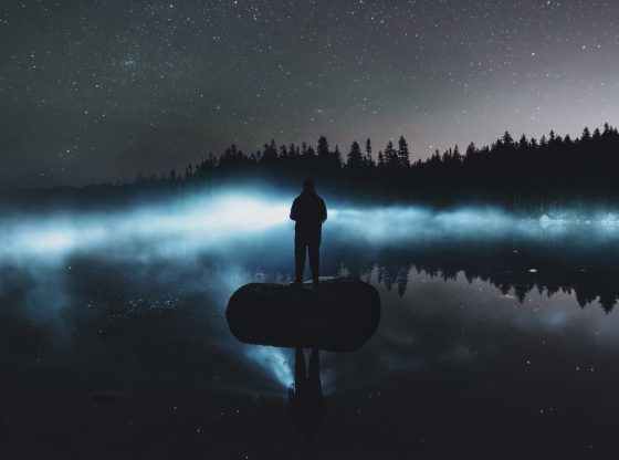silhouette of man with glowing lake