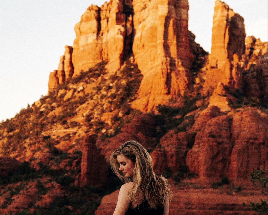 woman standing in front of Sedona red rock formation