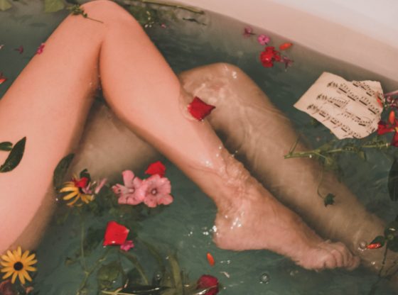legs in bathtub with flowers