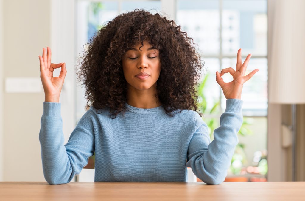 African american woman at home relax and smiling with eyes closed doing meditation gesture with fingers.
