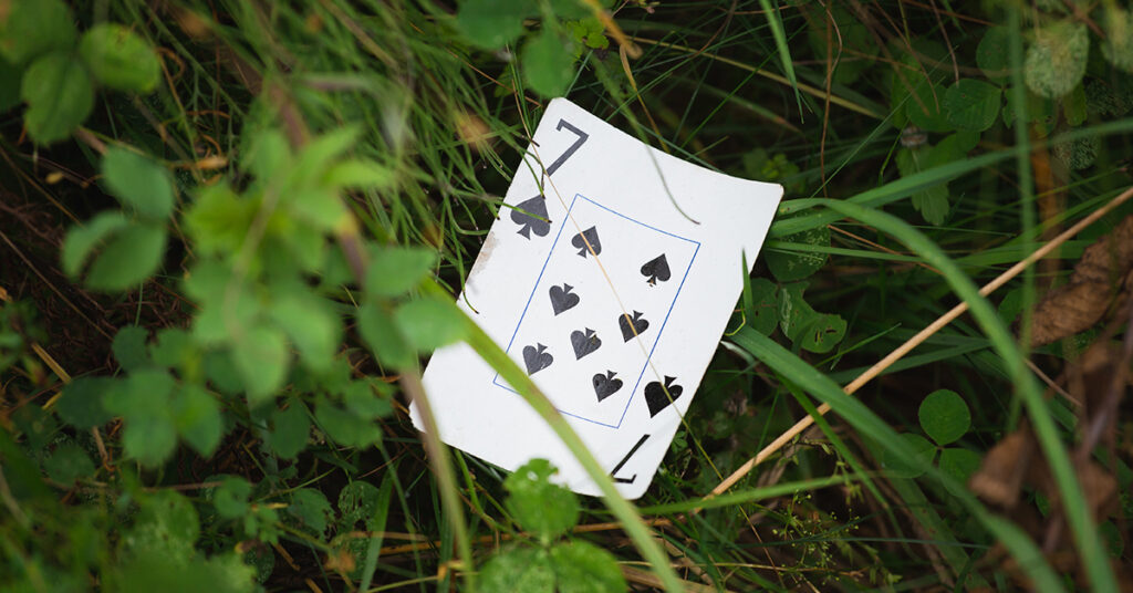7 of spades card is showcased in grass to represent the meaning of this card