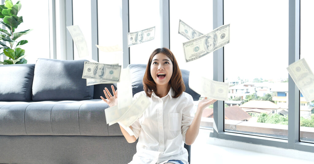 a happy asian woman throwing money in the air