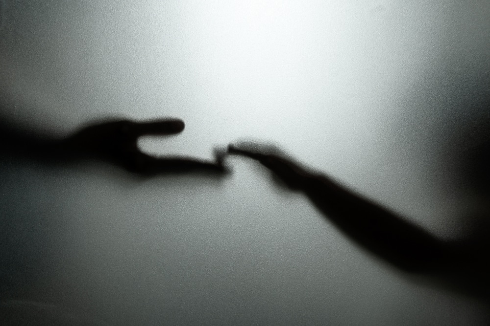 Shadow of two hands touching
