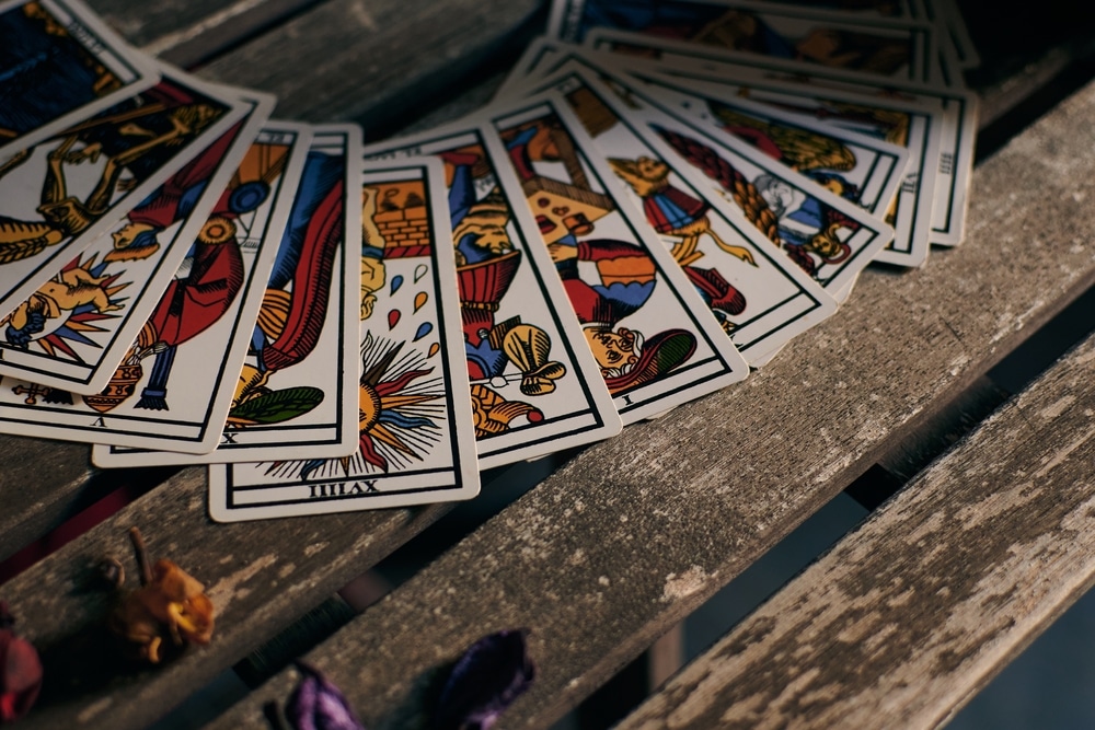 Tarot cards on a wooden table being used in a psychic reading.
