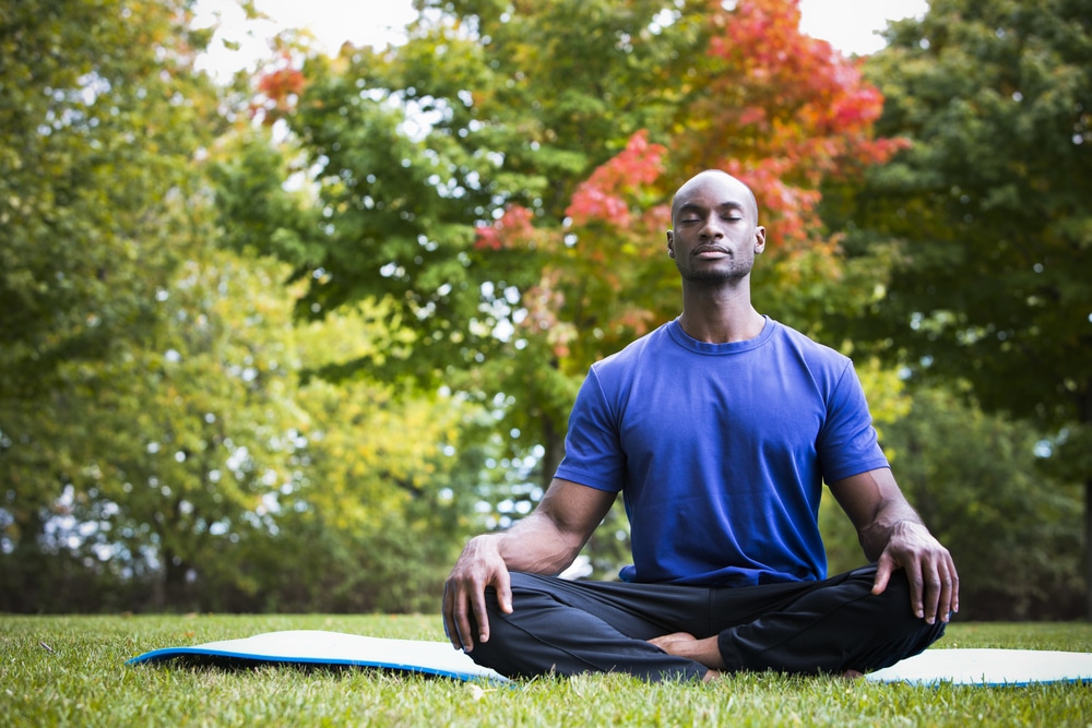 A man sitting outside doing a zen meditation