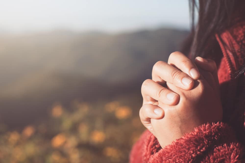 Close up of hands in prayer during a spiritual awakening.