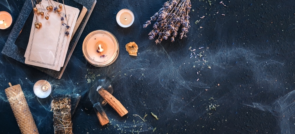Full moon ritual items such as sage, candles, and palo santo